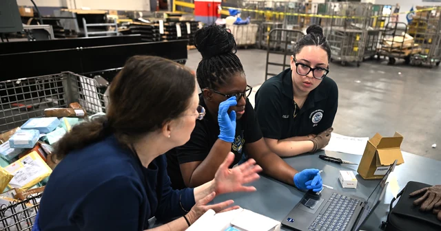 U.S. Customs and Border Protection officers inspecting international mail for counterfeit pharmaceuticals at the John F. Kennedy International Airport mail facility.